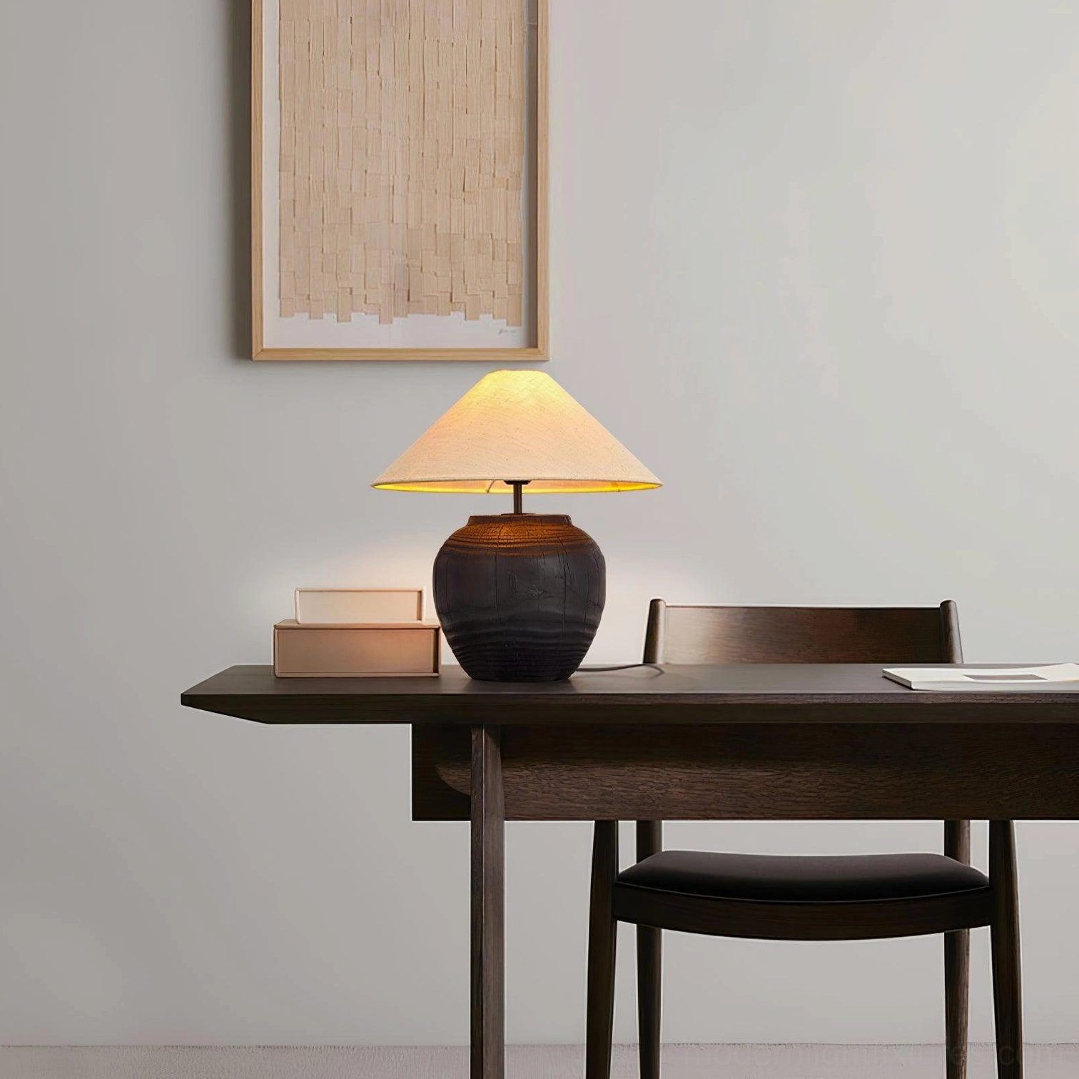 Textured black resin table lamp on home office desk with minimalist wall art