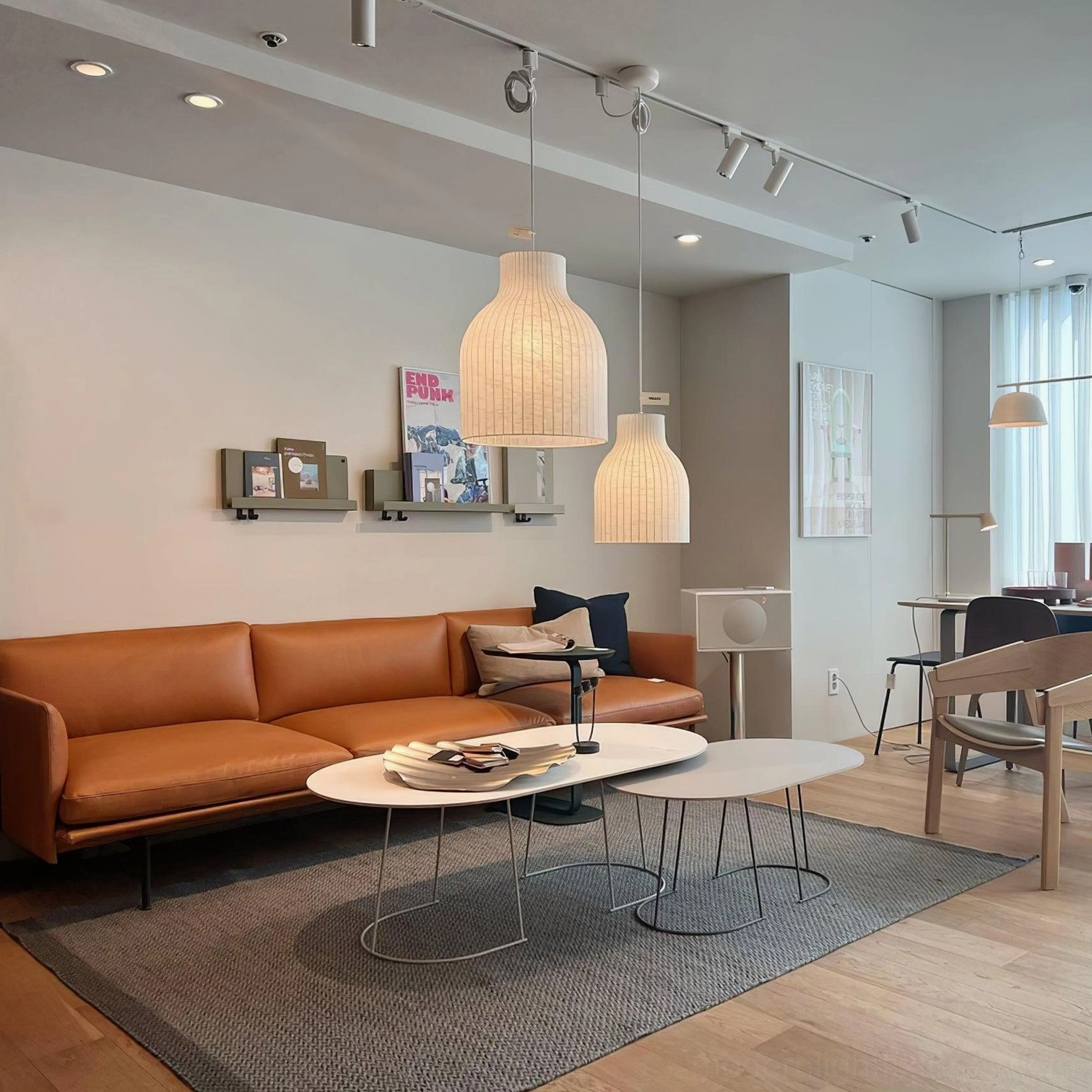 Two beige ribbed pendant lamps in minimalist living room with leather sofa and contemporary decor