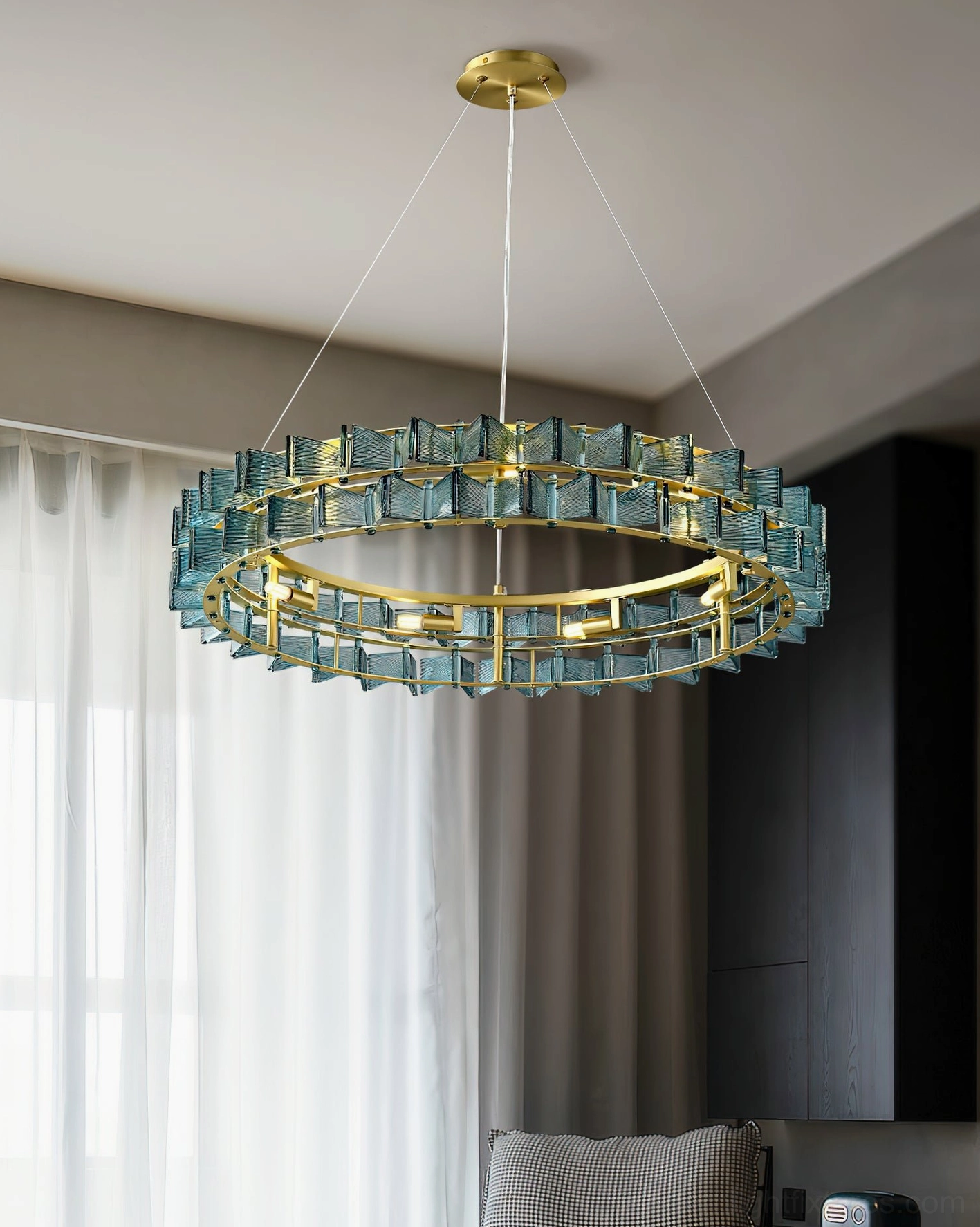 Modern teal glass ring chandelier suspended from ceiling with sheer curtains in contemporary interior