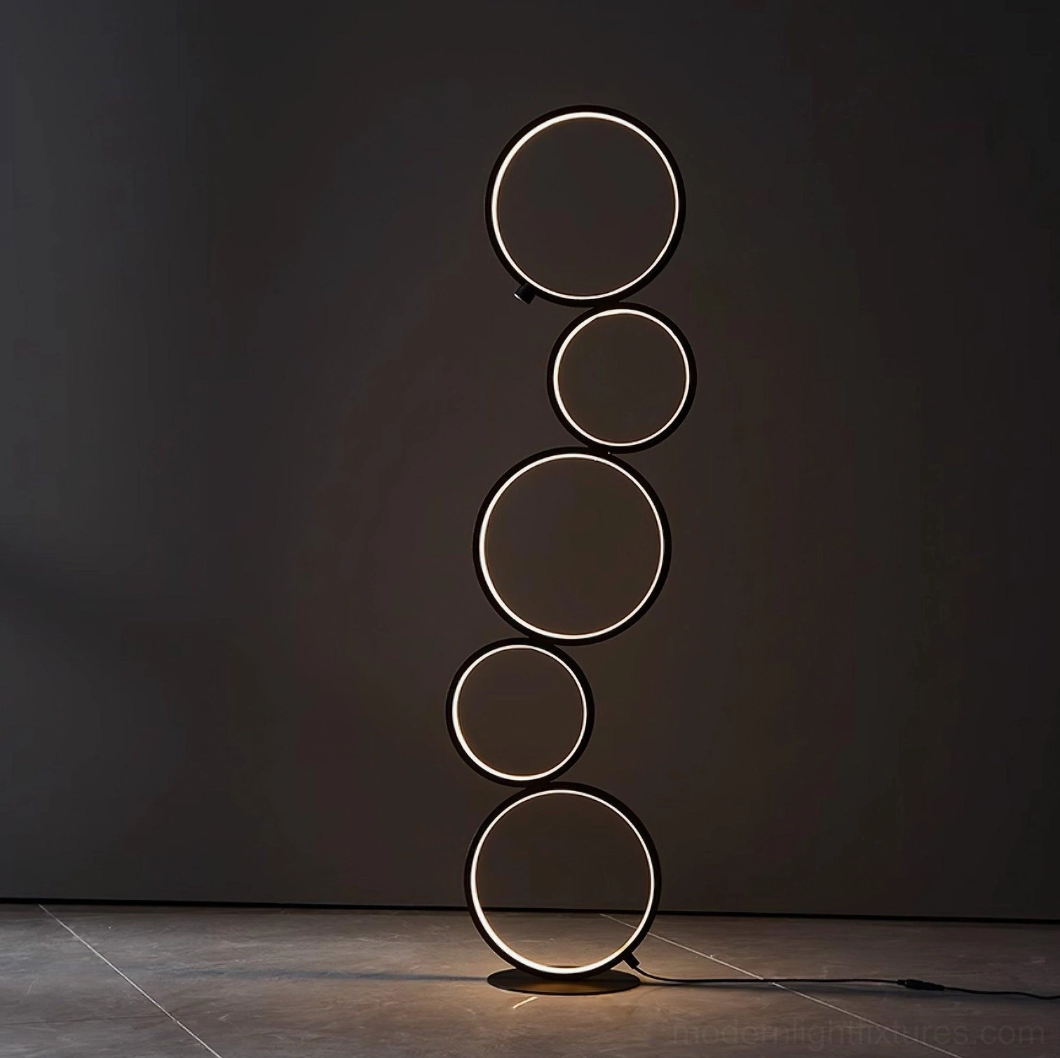 Contemporary circular LED ring floor lamp with glowing light rings on dark marble floor, minimalist modern aesthetic