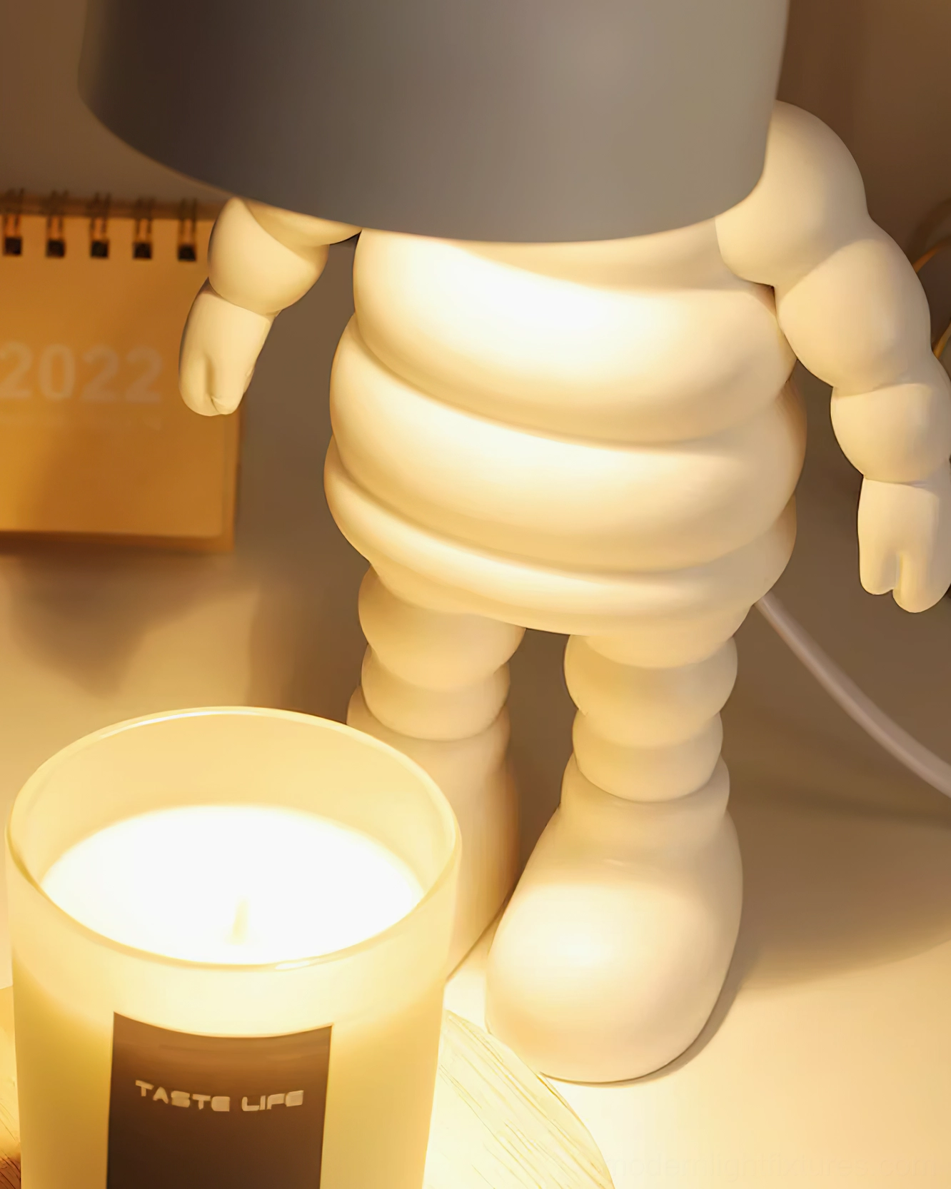 Modern robot candle warmer table lamp showcasing sculptural white ceramic design and functional dome heating element