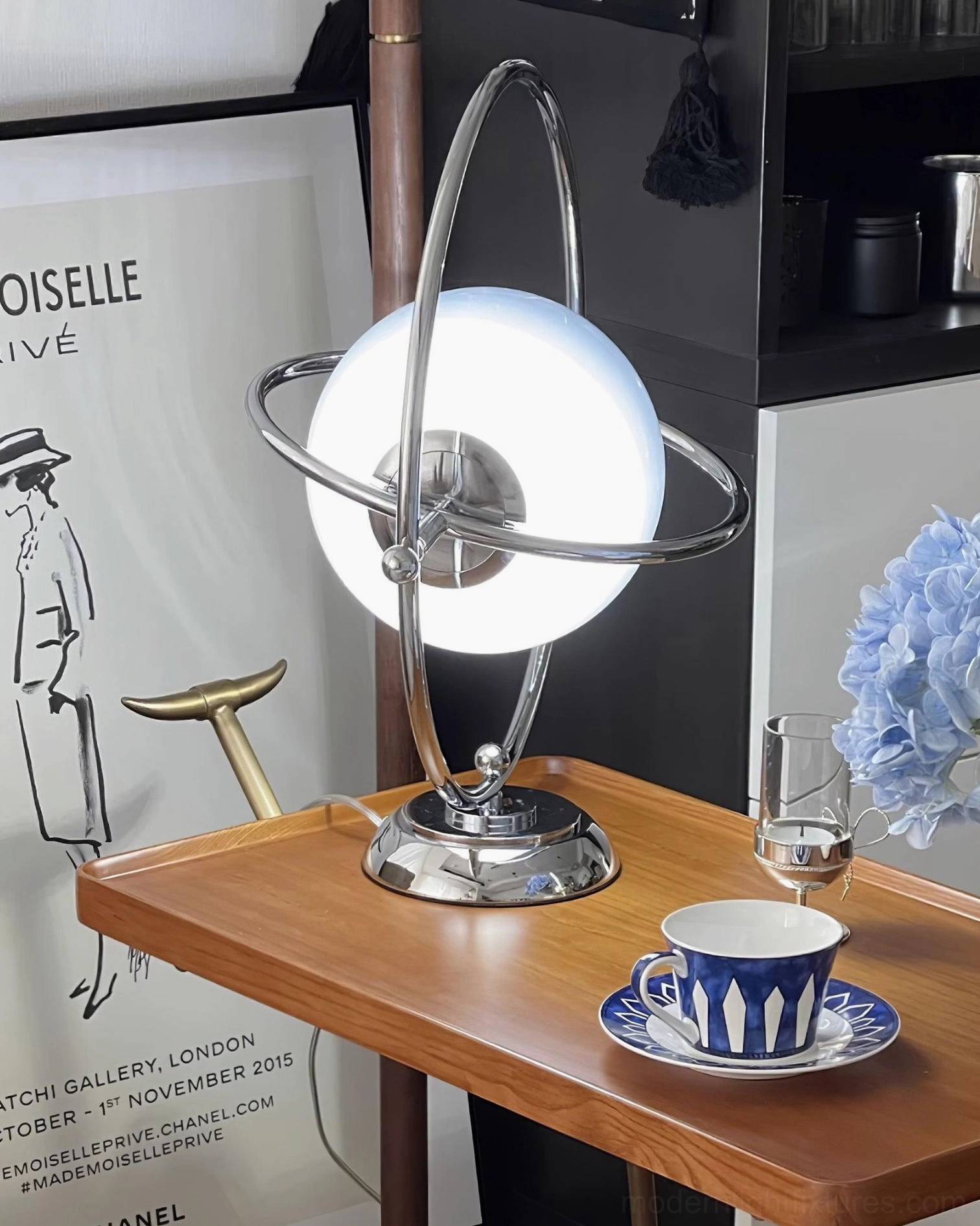 Bright white globe table lamp with chrome metalwork illuminated on side table