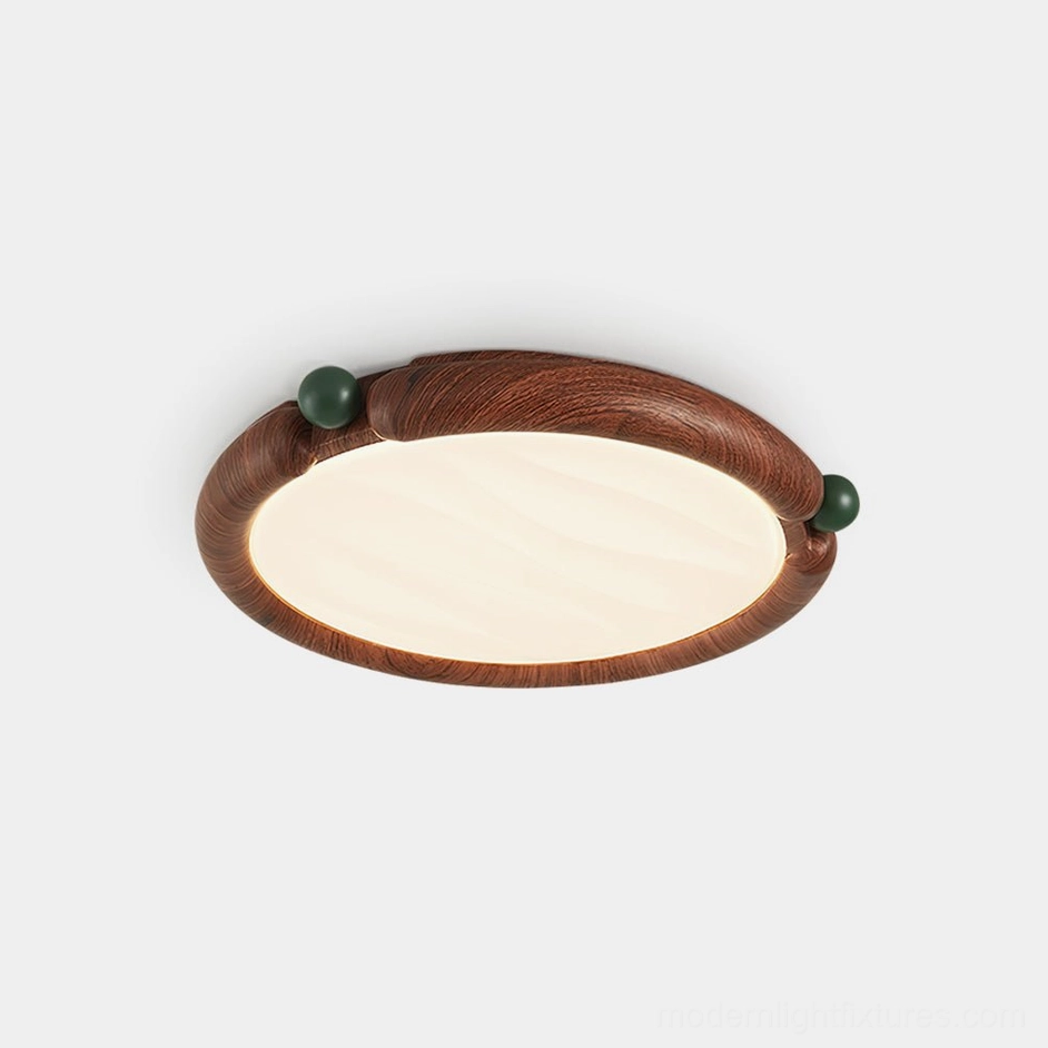 Modern round wood-grain ceiling light with green decorative balls and frosted white shade, front studio view
