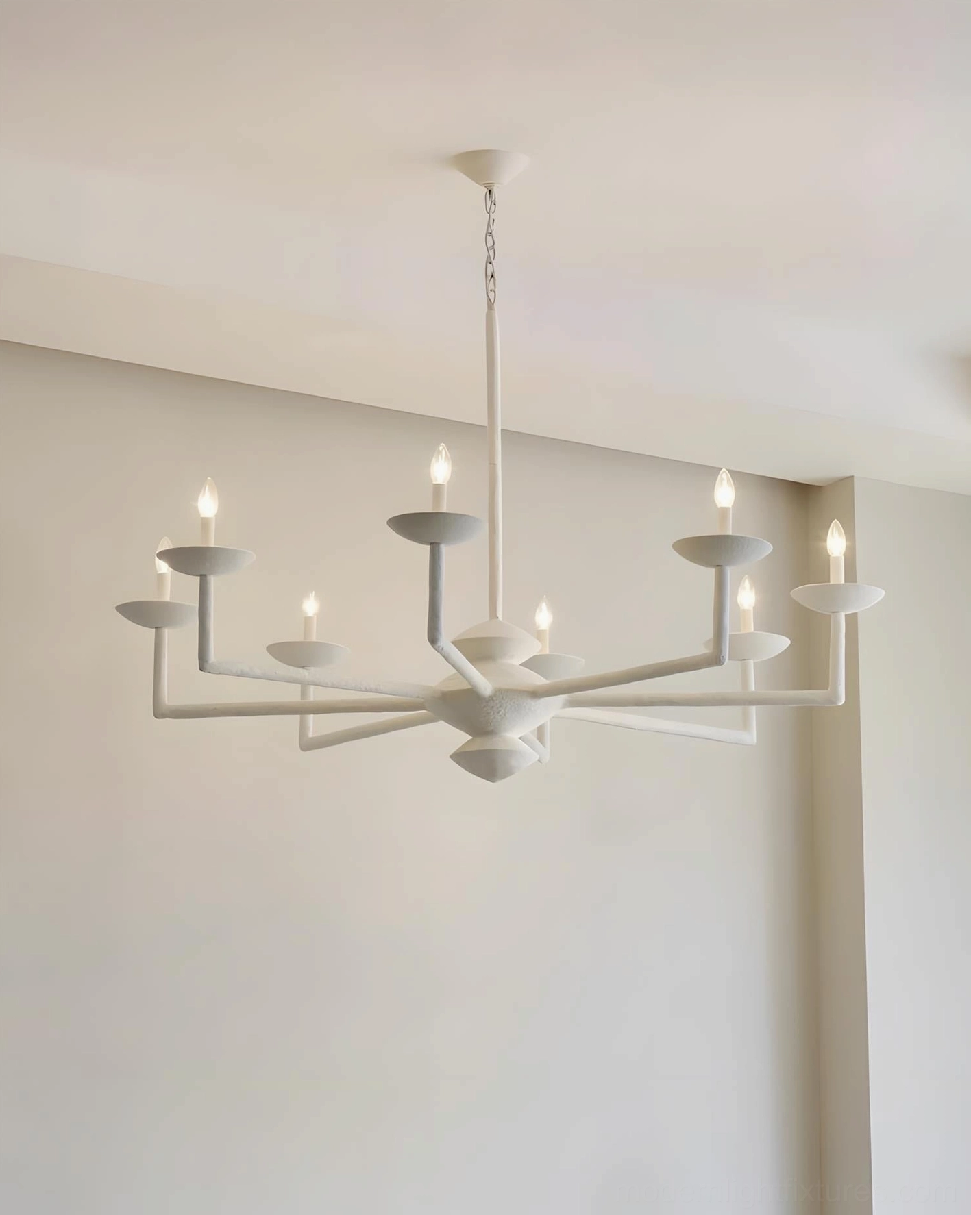 Textured matte white multi-arm chandelier side view in beige-toned living area, organic design aesthetic