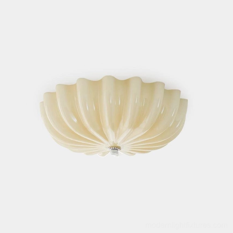 Modern jelly shell ceiling light with ribbed glass shade and spiral scalloped edges in creamy white finish, studio front view