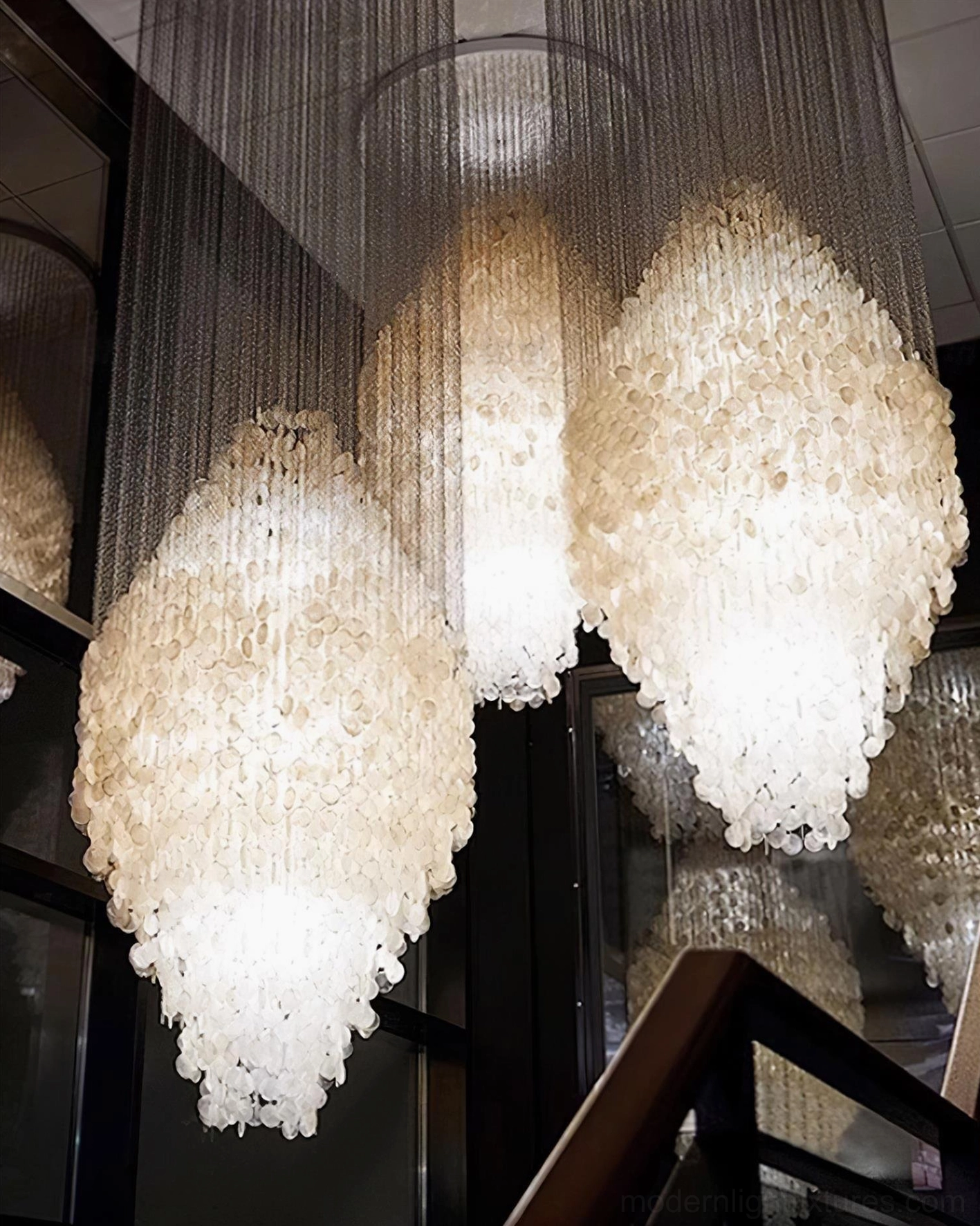 Modern shell chandelier in bright interior space highlighting natural light interaction with shell material