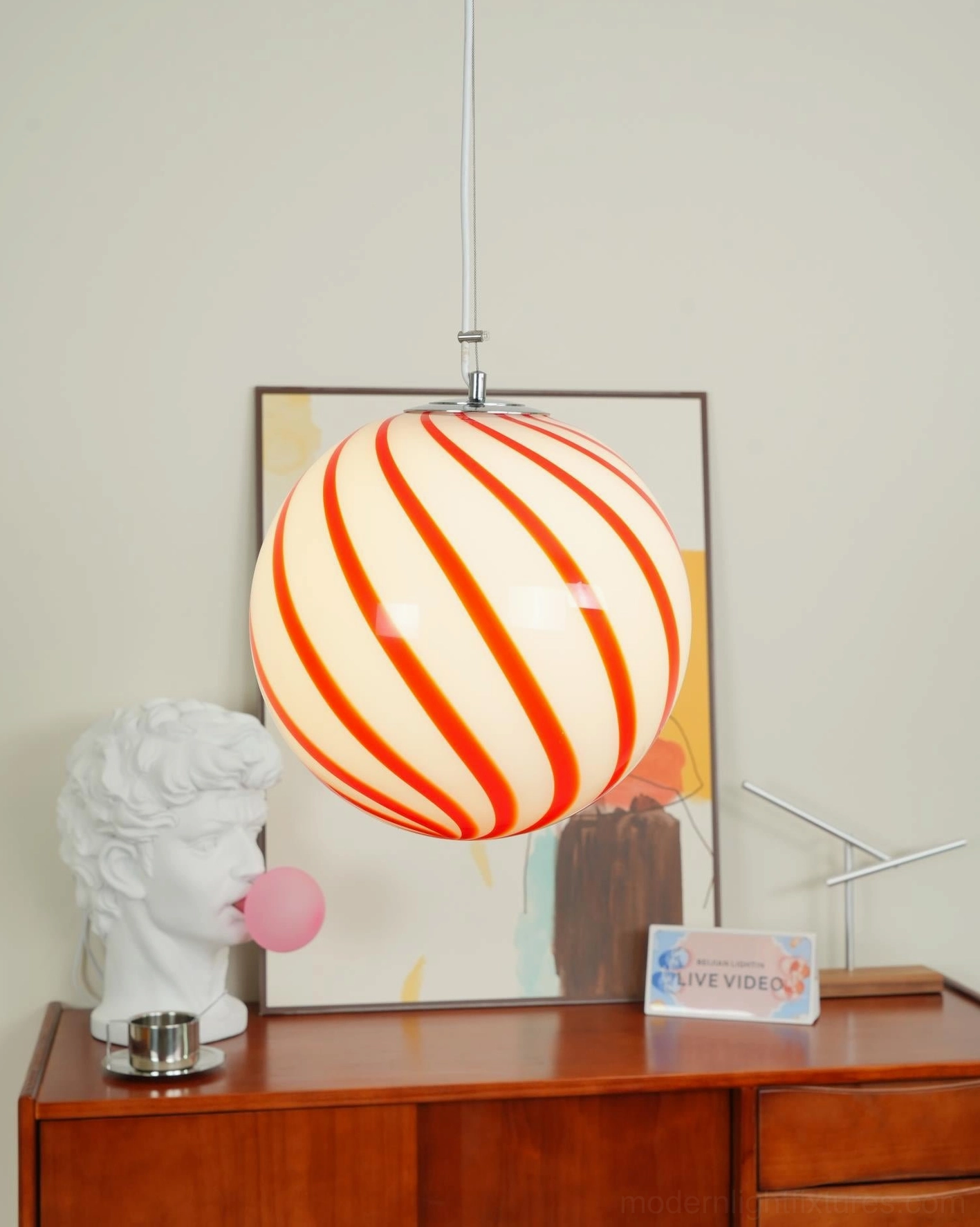Modern pendant lamp with spiral stripe glass globe, showing installation height and proportions in residential dining space