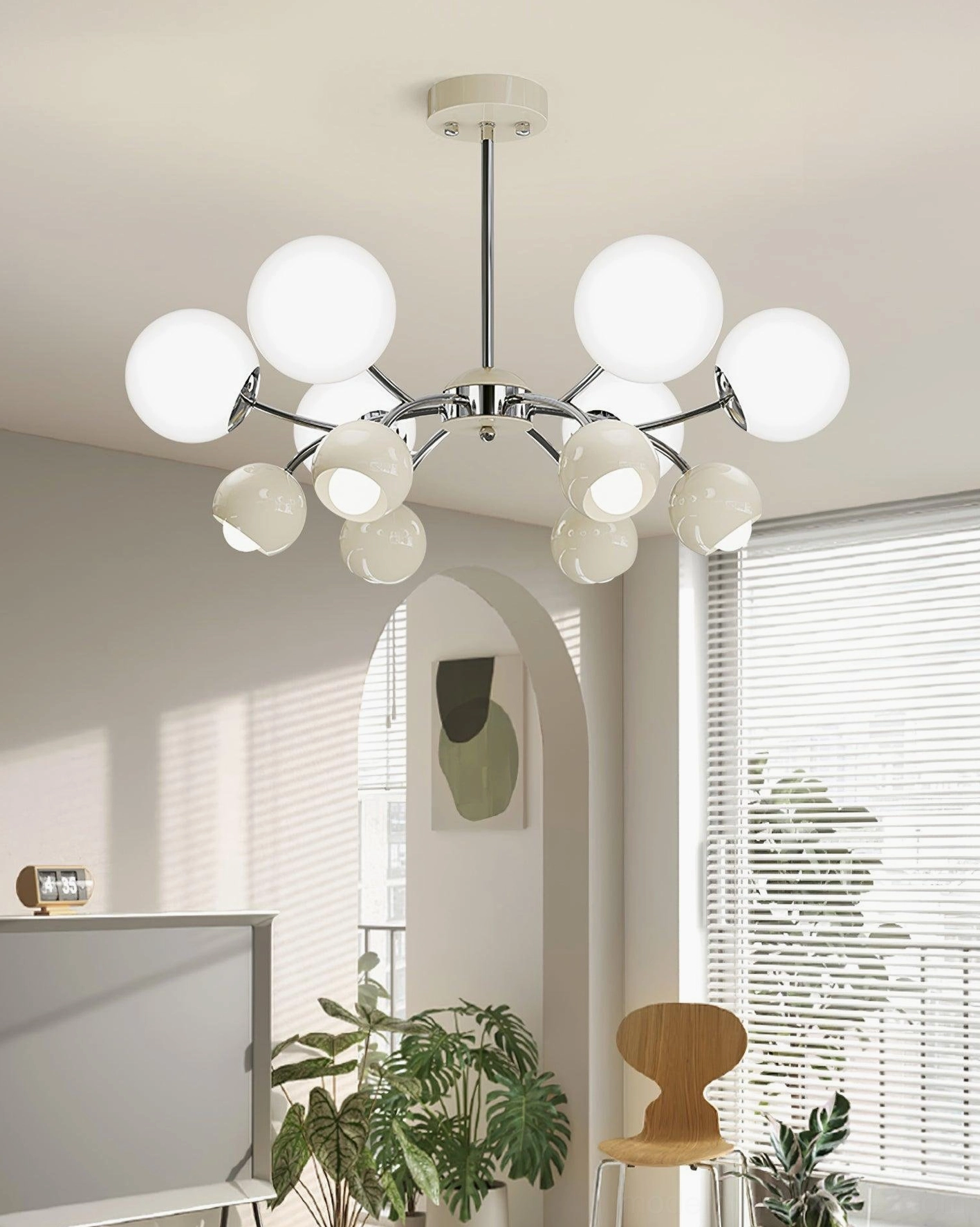 Contemporary Sputnik chandelier with frosted white globe shades and chrome metal arms, installed in sunlit living room with window blinds