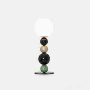 Modern stacked sphere table lamp with black green and gold metallic base and frosted white glass shade on white background