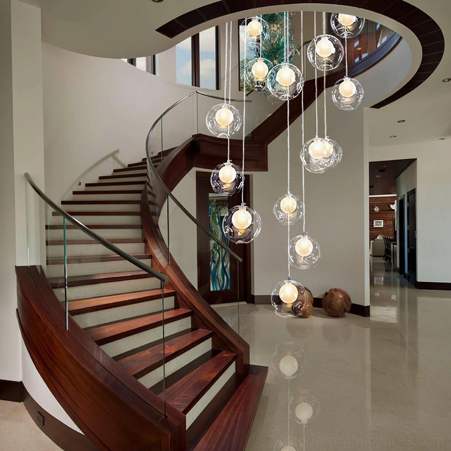 Symmetrical clear glass globe pendant chandelier installed in modern luxury residential stairwell hallway, contemporary minimalist design