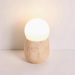 Warm white 3000K LED bedside lamp on light tabletop, organic stone texture detail