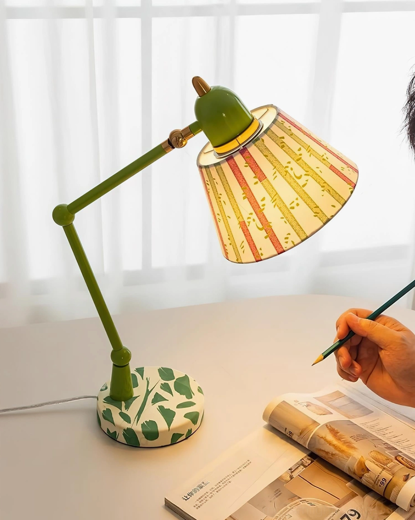 Contemporary swing arm table lamp with green metal frame and artistic striped lampshade in home study setting