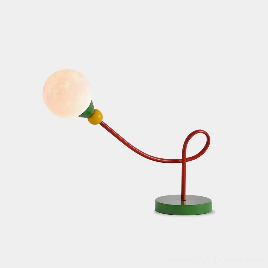 Vitan modern table lamp with bold red curved metal arm and green base, front studio view