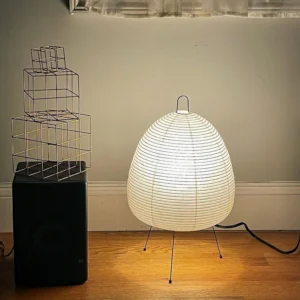 Illuminated modern table lamp with warm light in minimalist home interior, three-quarter view