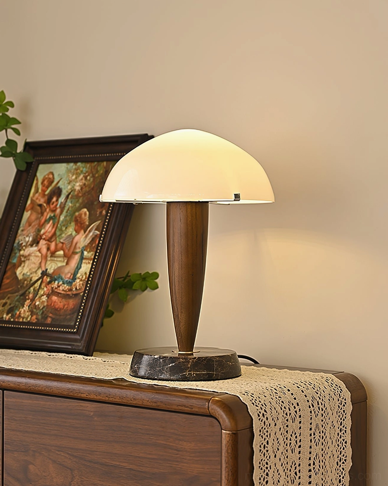 Contemporary table lamp front view on dresser with warm ambient lighting, lace table runner, and vintage painting - interior décor