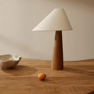 Modern Alvin table lamp positioned on wooden dining table in minimalist Scandinavian interior setting