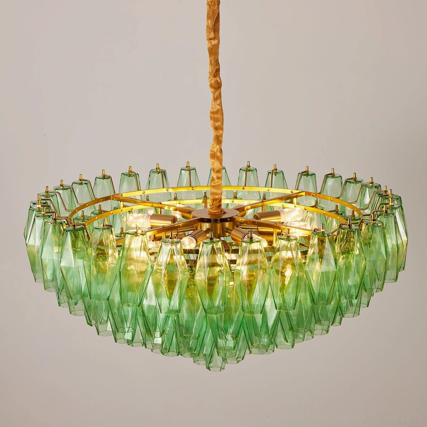Modern tiered glass chandelier in dimly lit interior highlighting glass prism illumination effects