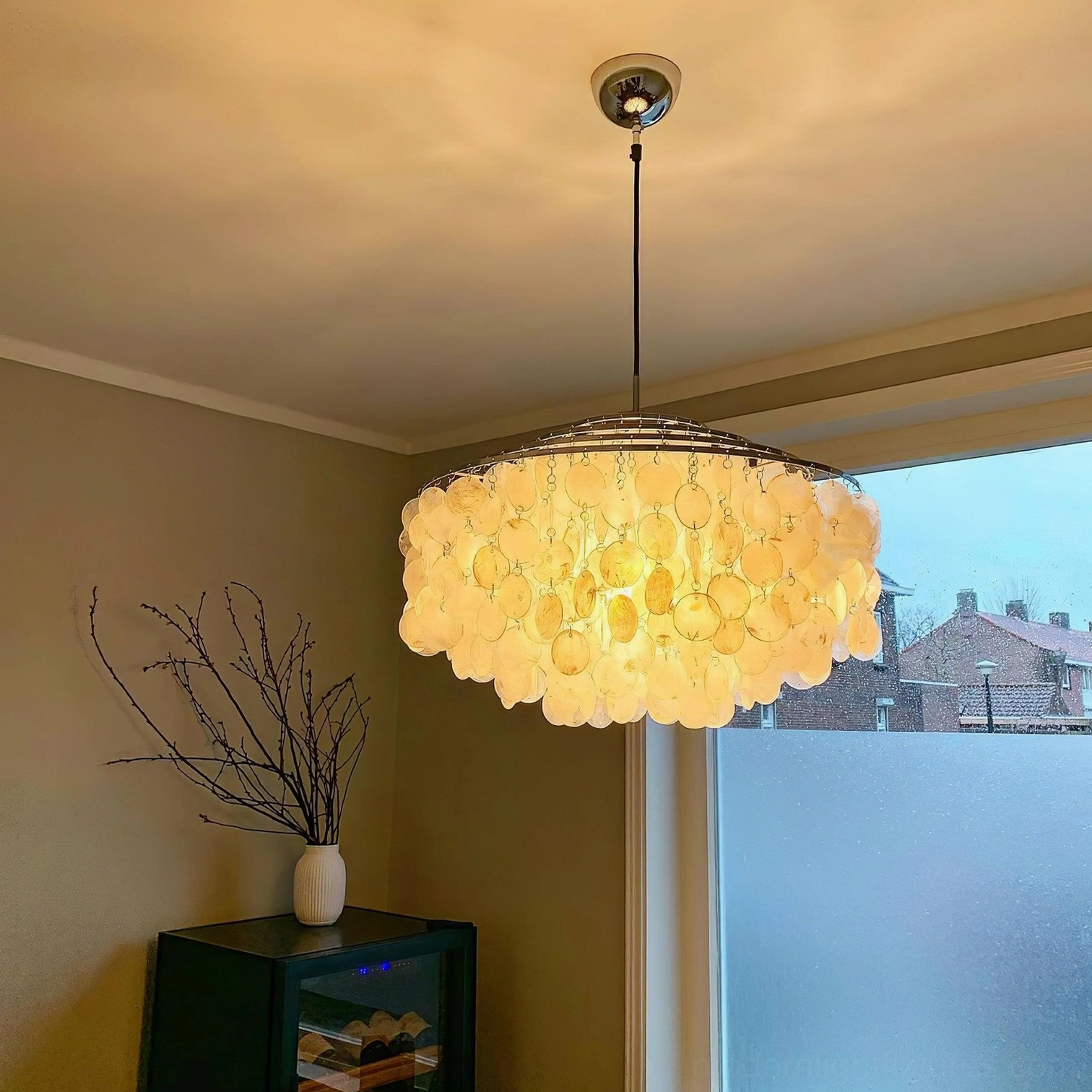 Modern tiered shell chandelier showing light diffusion and shadow interplay detail
