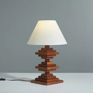 Modern geometric wooden tower table lamp three-quarter view showing sculptural stacked wood structure and fabric shade with power cord