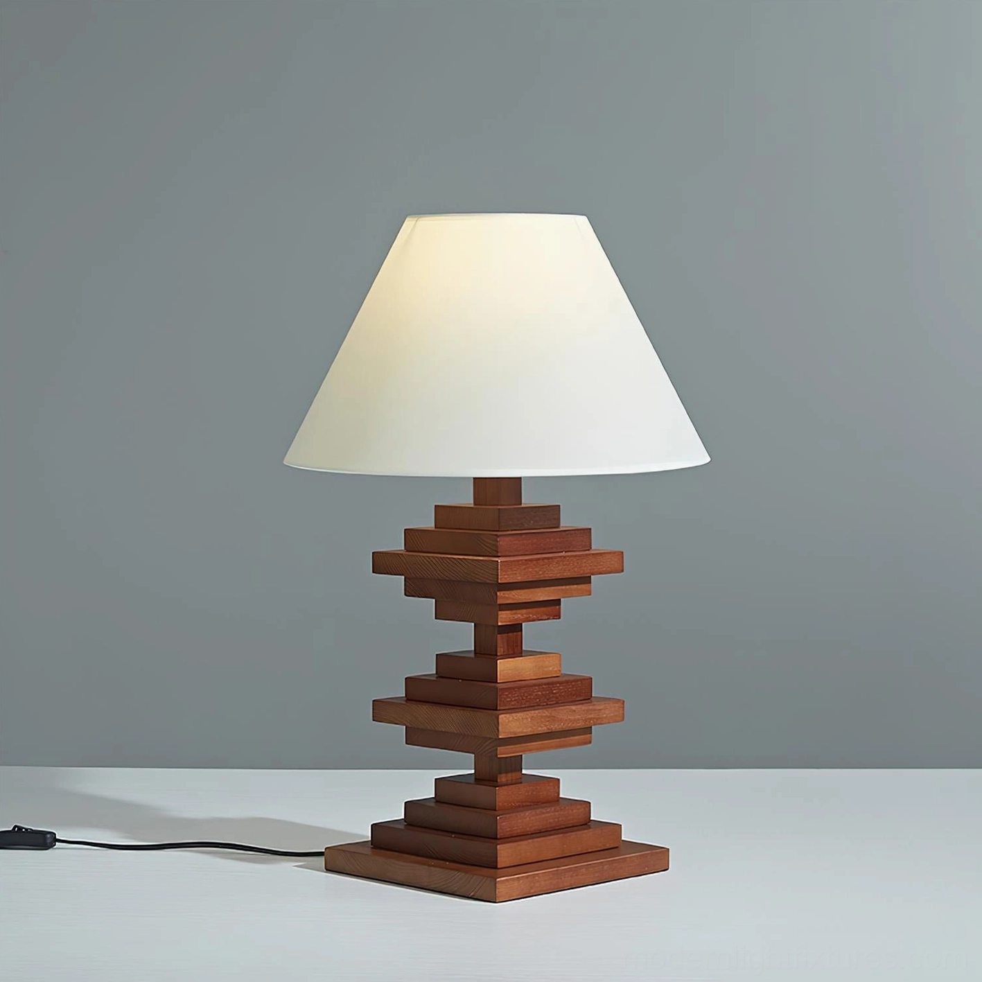 Modern geometric wooden tower table lamp three-quarter view showing sculptural stacked wood structure and fabric shade with power cord