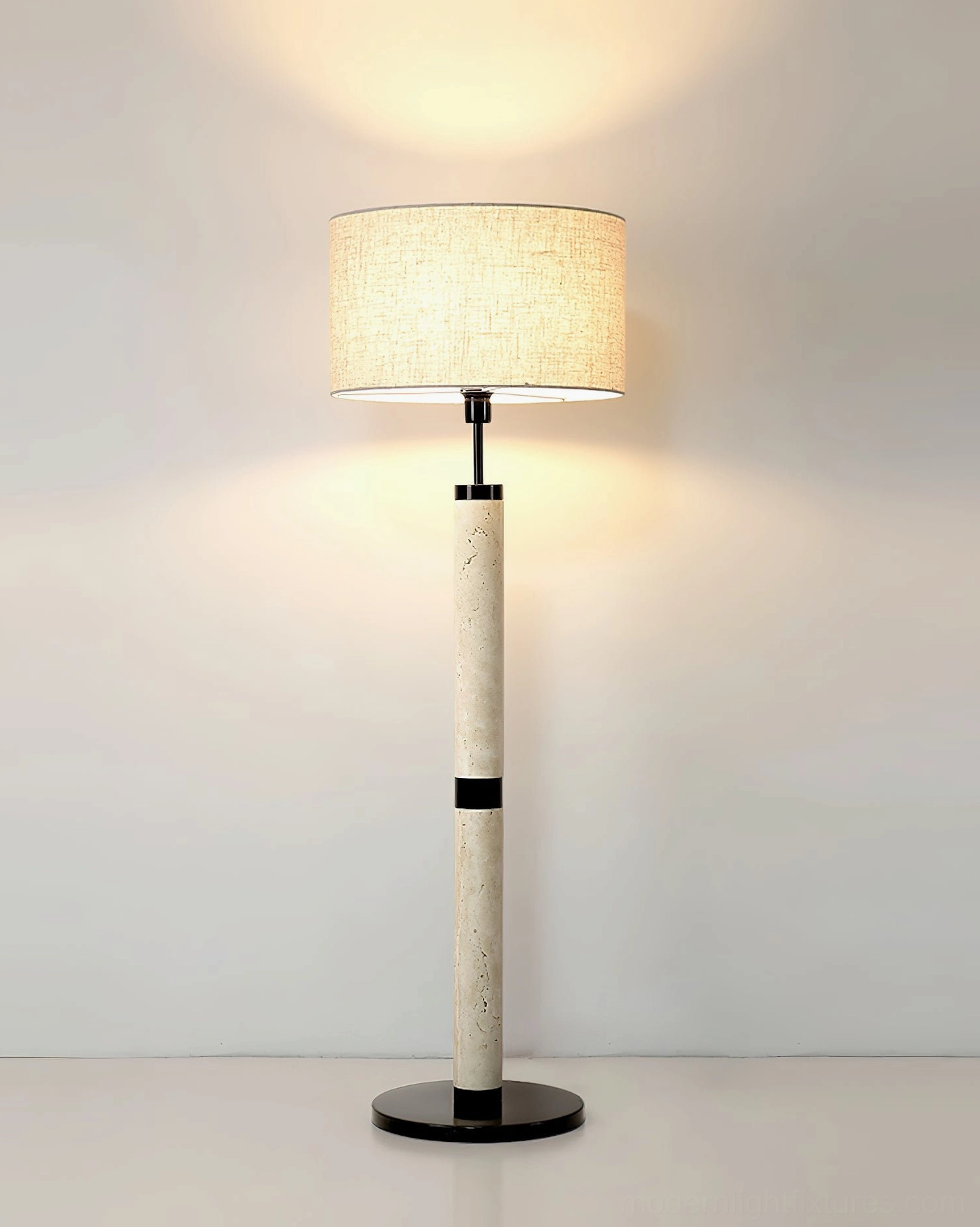 Lit travertine stone floor lamp with warm glow in minimalist living space - architectural design statement