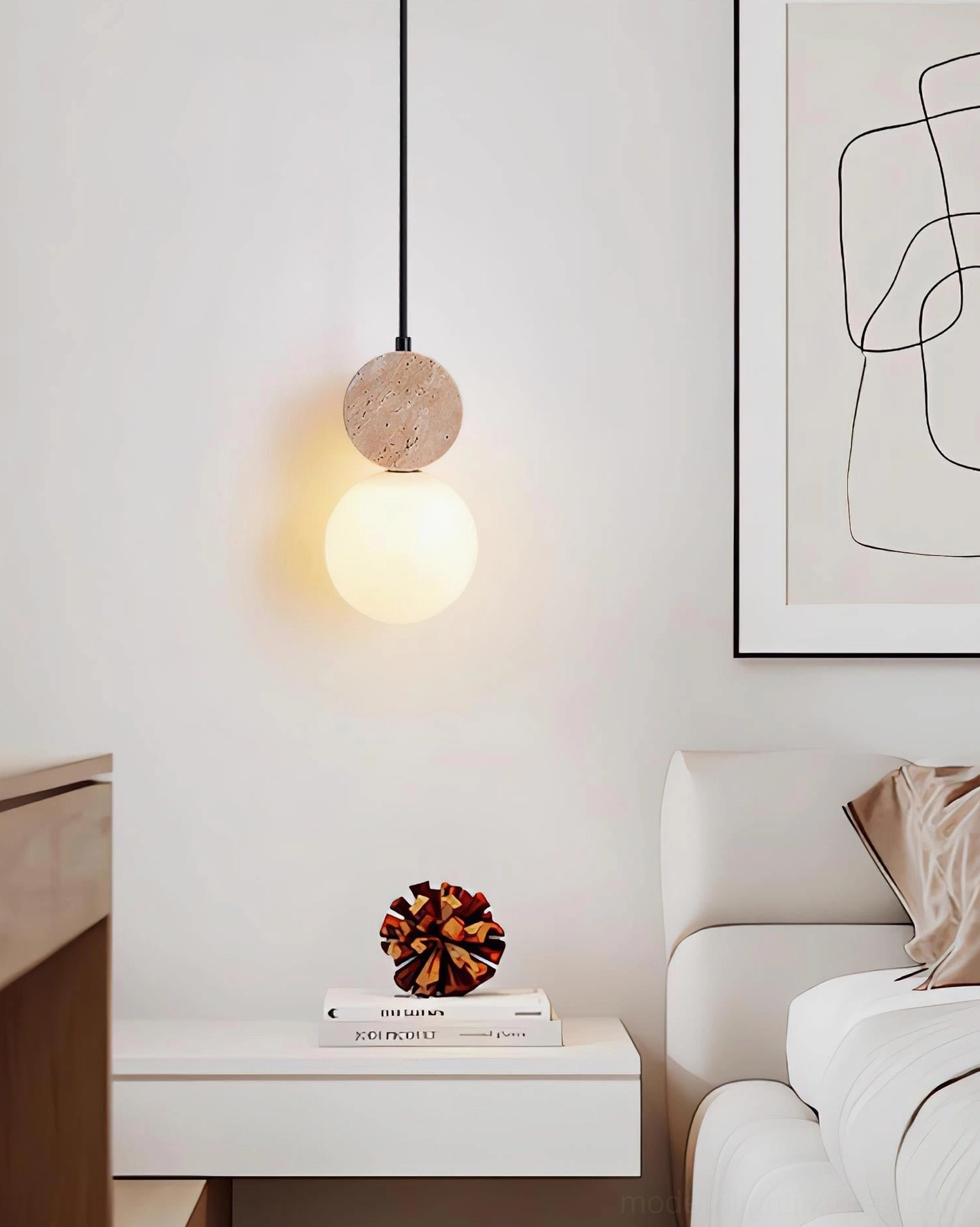 Single Cenari travertine pendant with glowing frosted glass shade beside minimalist white nightstand and wall art