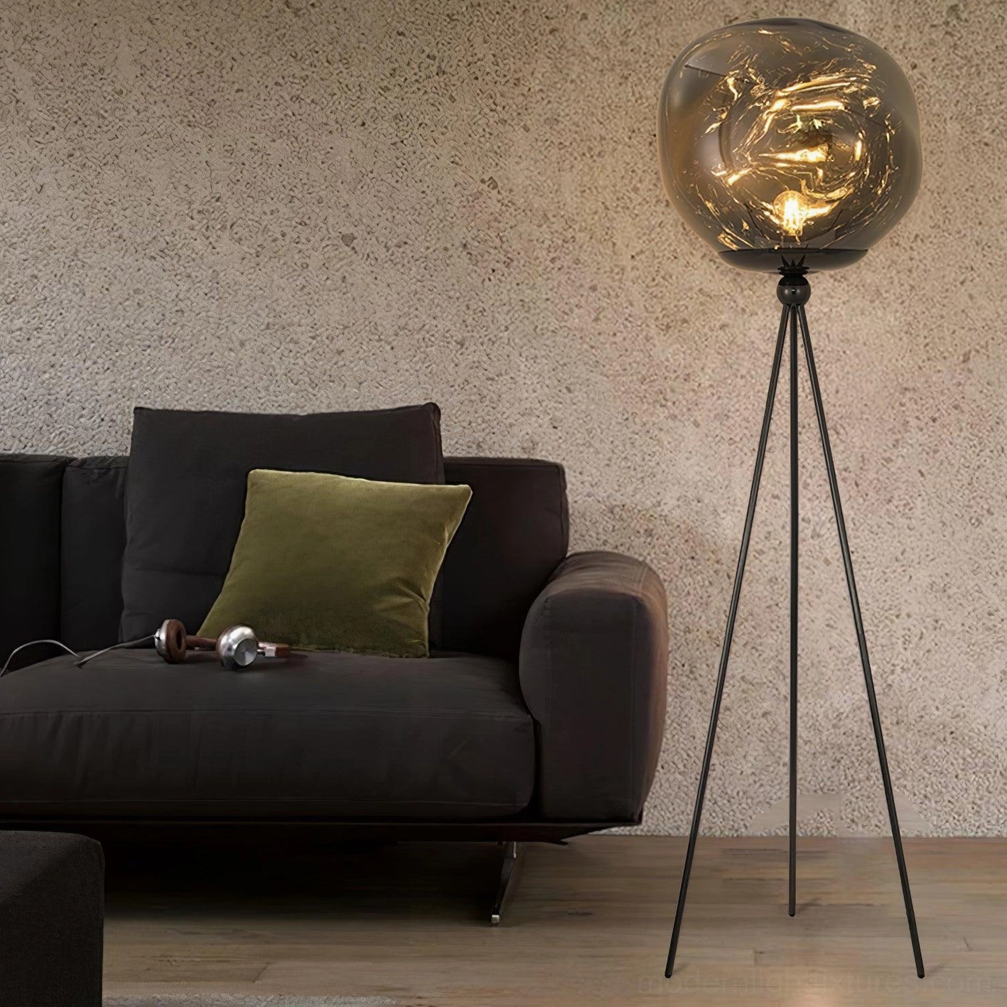Minimalist black tripod floor lamp with irregular molten glass shade in contemporary living room with textured wall