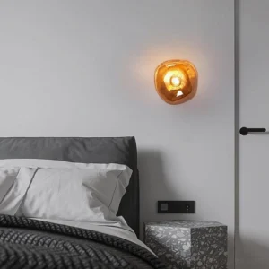 Modern bedroom with molten glass wall sconce providing warm ambient lighting above bedside