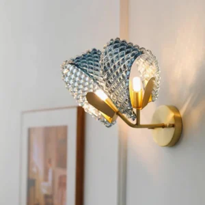 Luxury brass and blue glass wall lamp three-quarter close-up with warm ambient lighting, modern sconce fixture