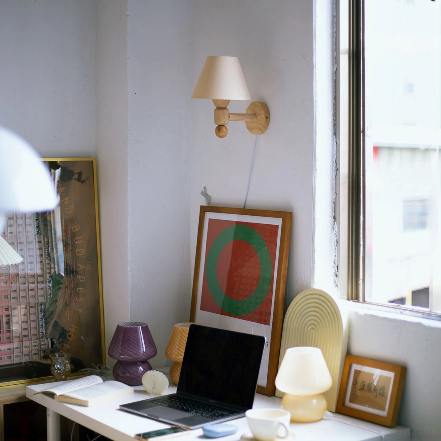 Minimalist wall sconce with cream beige shade positioned in modern home office workspace above decorated desk
