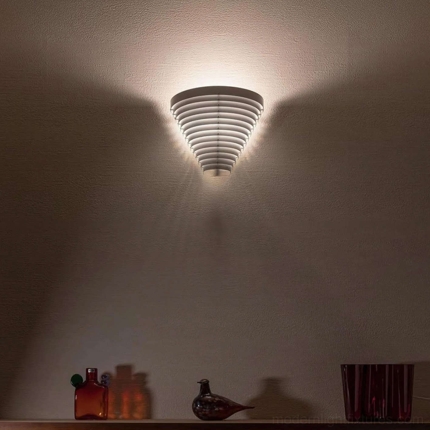 Modern minimalist wall sconce installed in living space above shelf, warm striped lighting effect