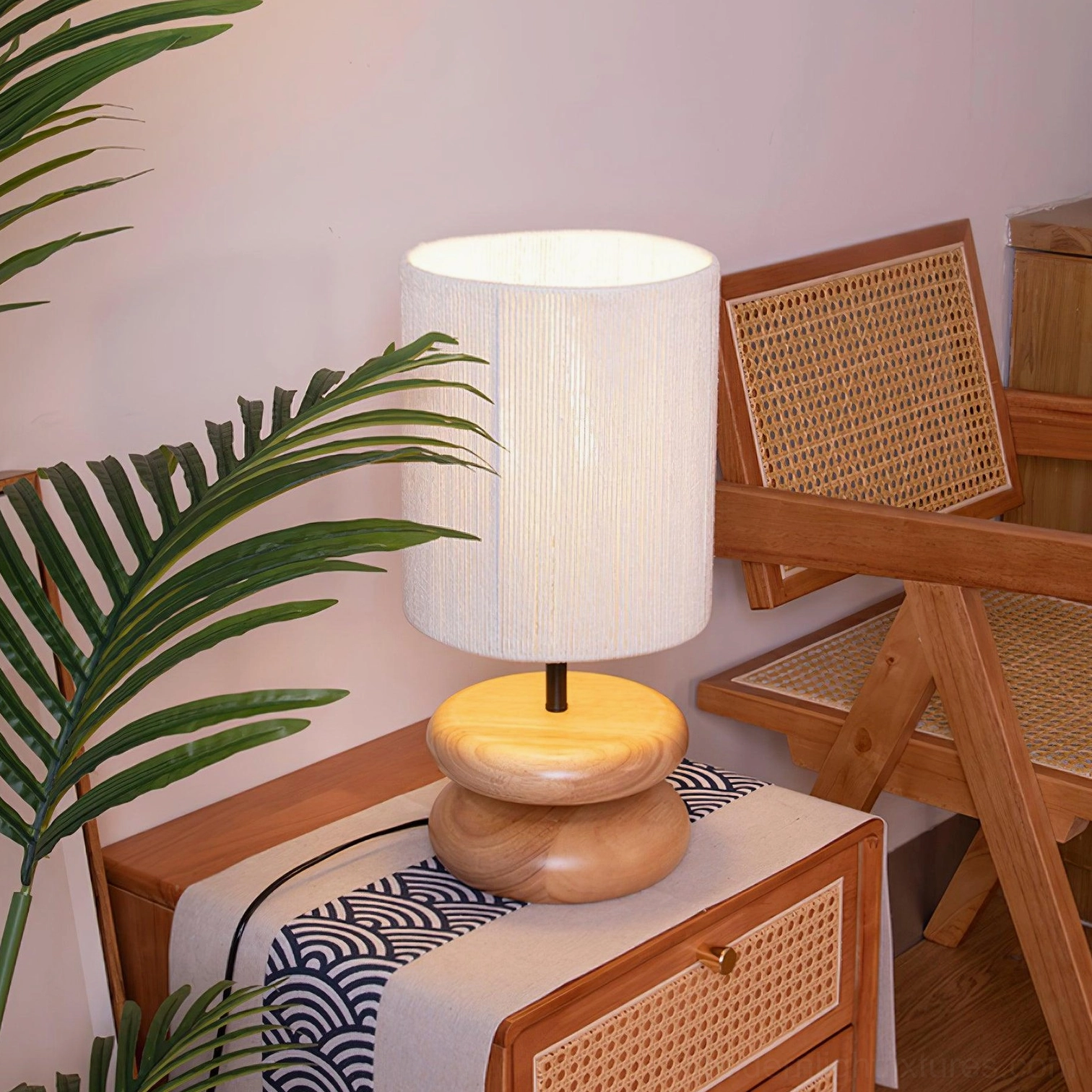 Modern walnut wood stacked lamp creating warm ambient lighting in home interior