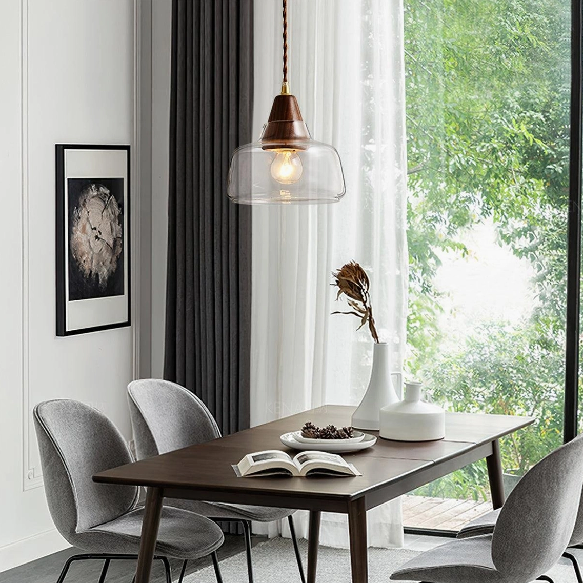 Modern walnut wood glass pendant light in bright dining room with wooden table and grey chairs, natural daylight
