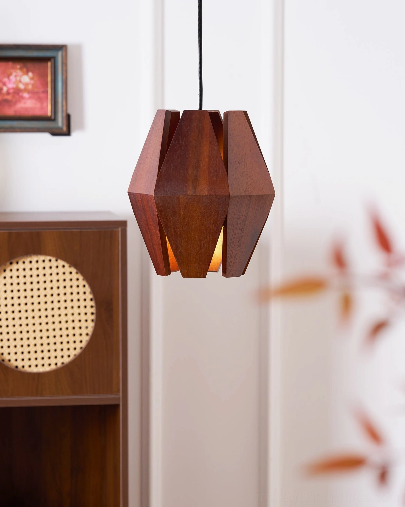 Walnut wood pendant lamp with metal frame creating soft ambient light in modern space