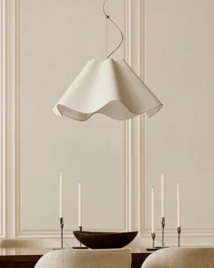 Modern wavy pendant light hung above dining table in Scandinavian minimalist interior with warm ambient lighting and neutral decor