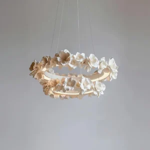 Modern white floral ring chandelier with warm beige flower accents, minimal gray wall background, contemporary lighting fixture