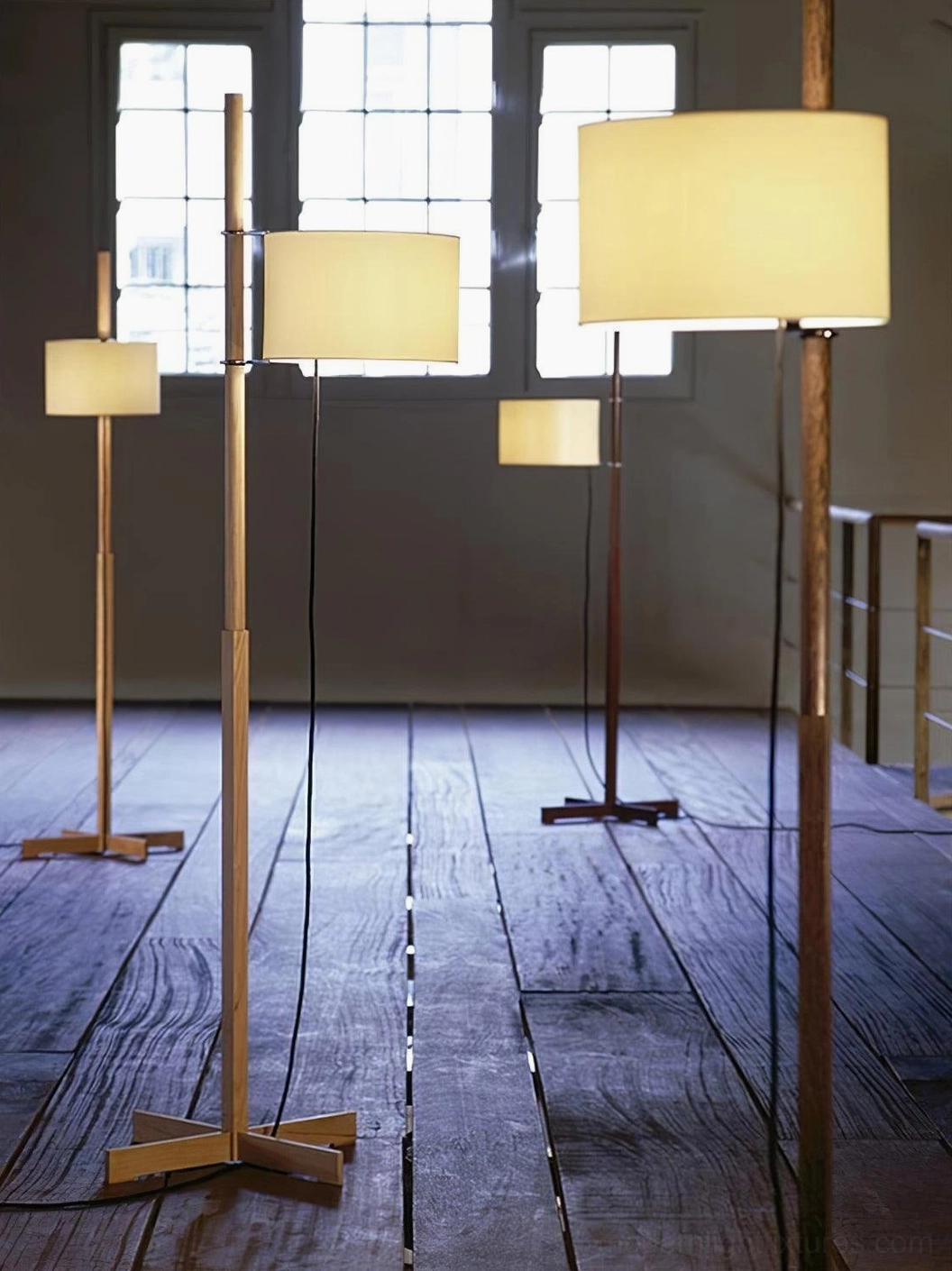 Multiple wooden floor lamps with varied heights in sunlit vintage room, wood-toned poles