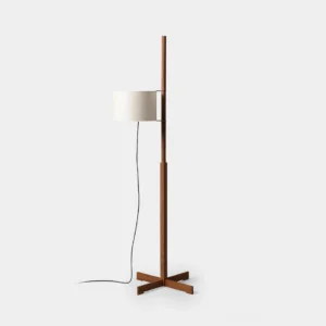 Modern minimalist wood floor lamp with white fabric drum shade and cross metal base, front studio view
