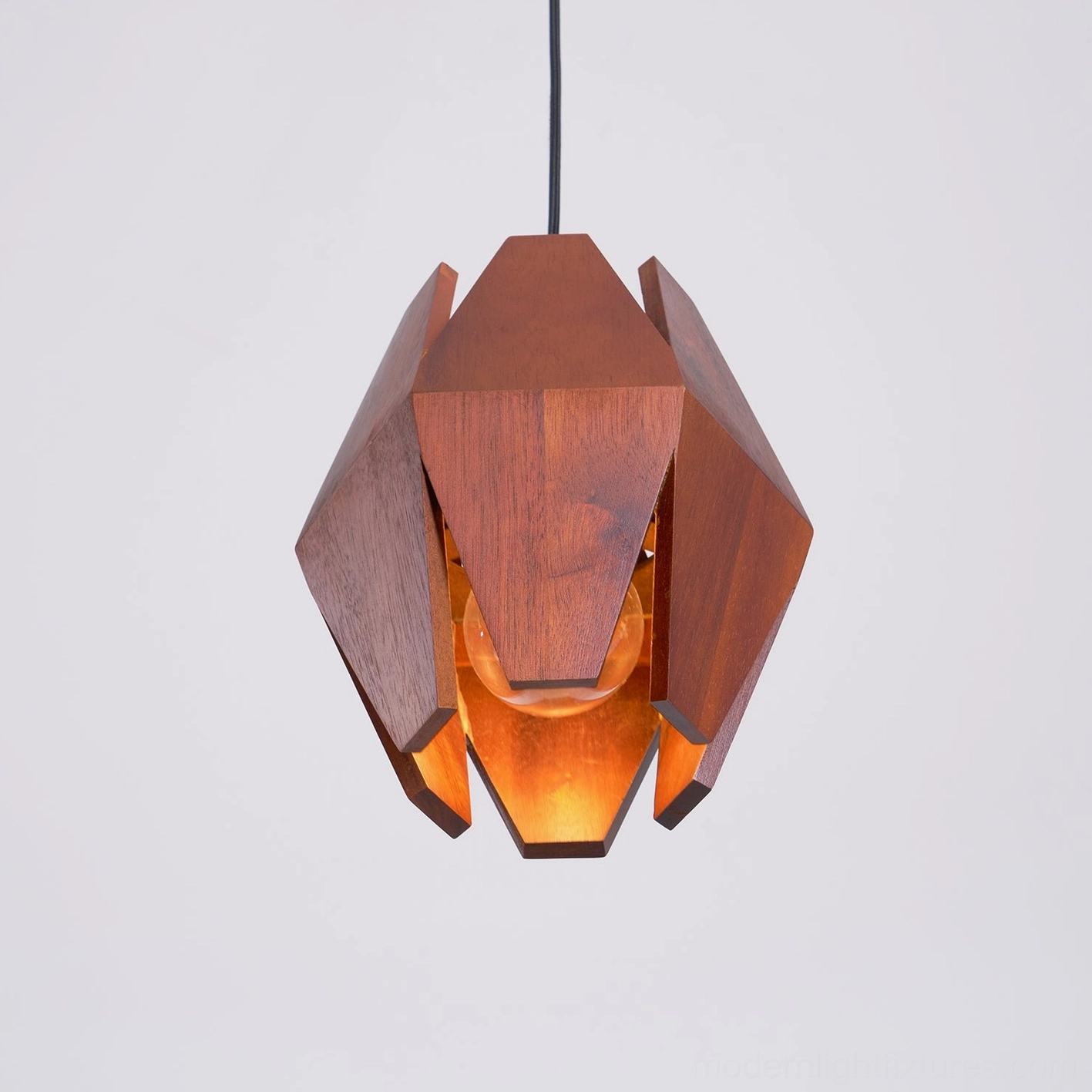 Modern wood pendant fixture with geometric facets creating artistic shadow patterns
