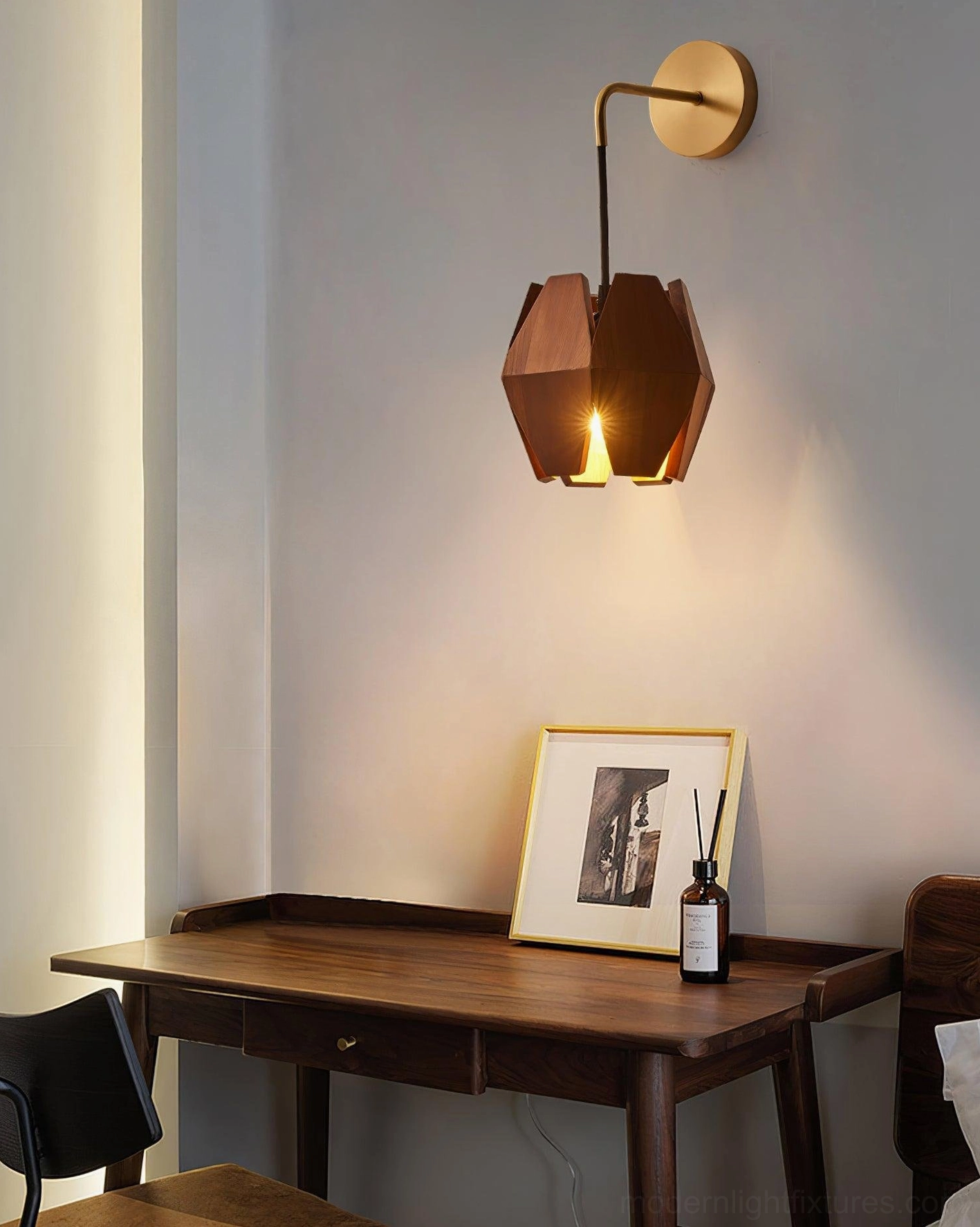 Geometric wood wall lamp mounted above vintage wooden desk in home office study area