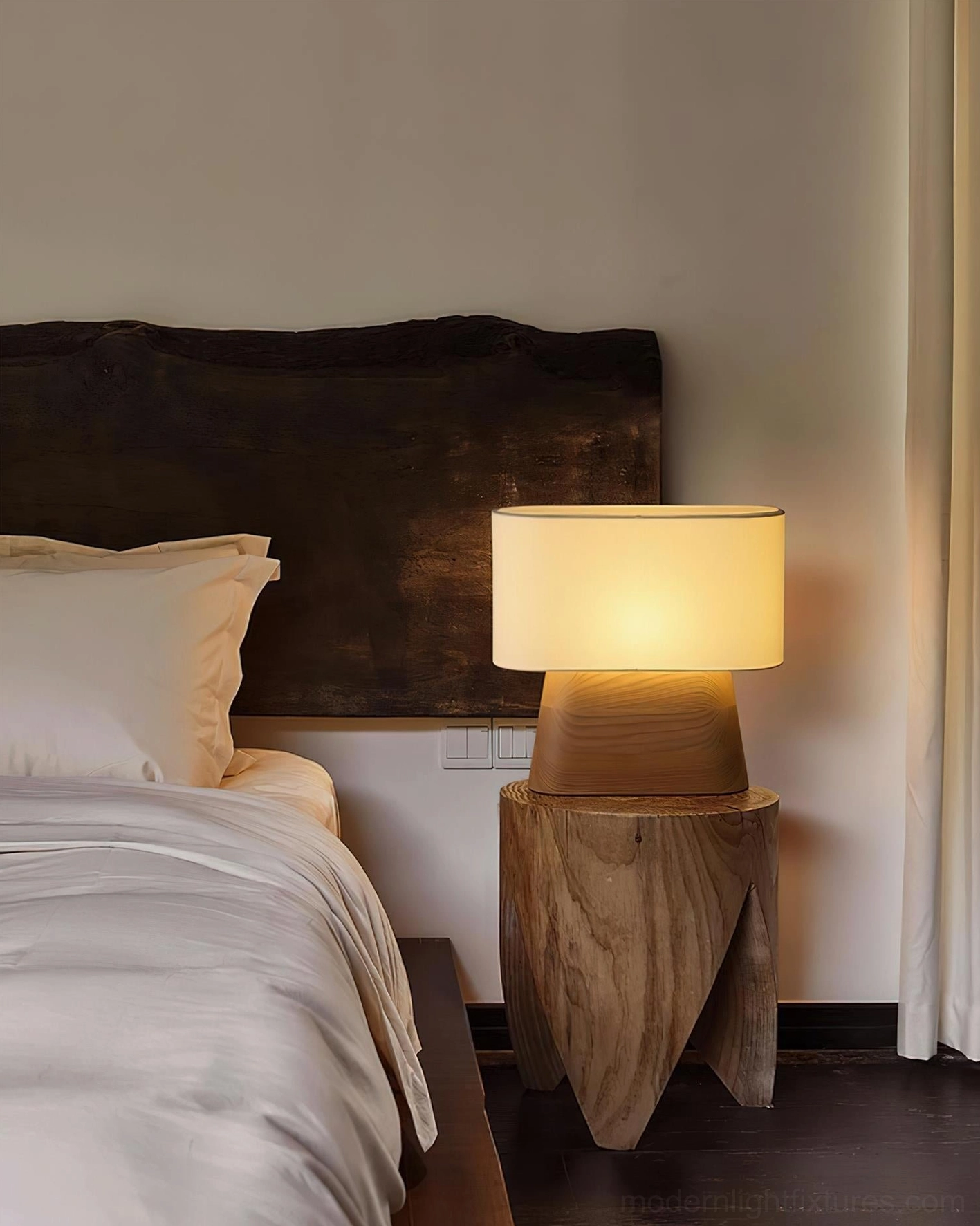 Modern wood table lamp with softly glowing fabric shade in ambient home interior lighting
