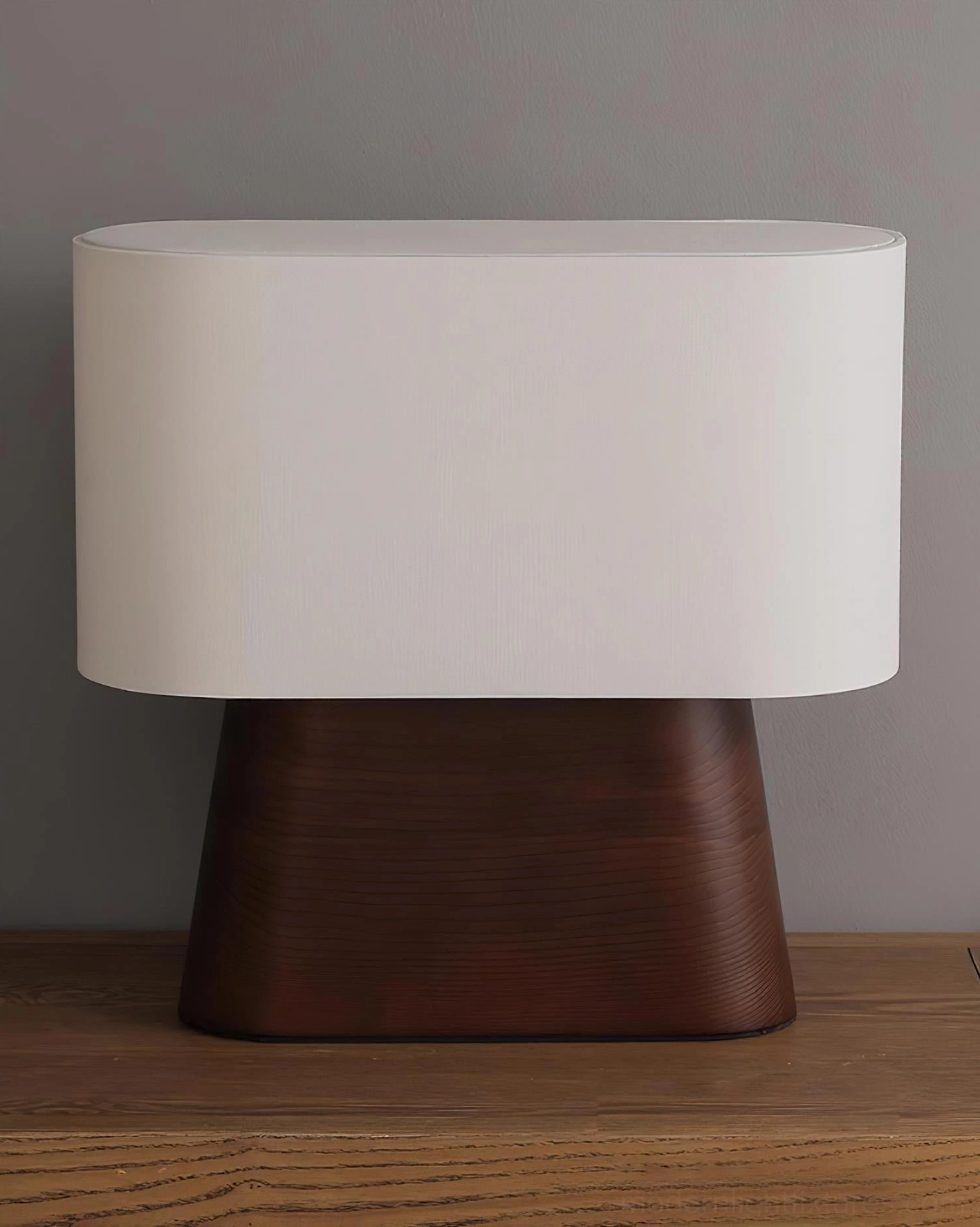 Minimalist table lamp with white shade and dark brown base on wooden tabletop