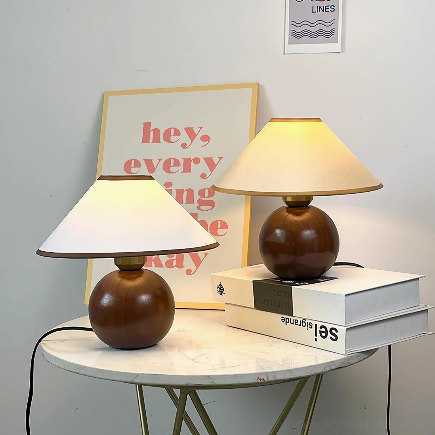 Modern wooden base lamp on marble side table with stacked books and wall art, minimalist home decor