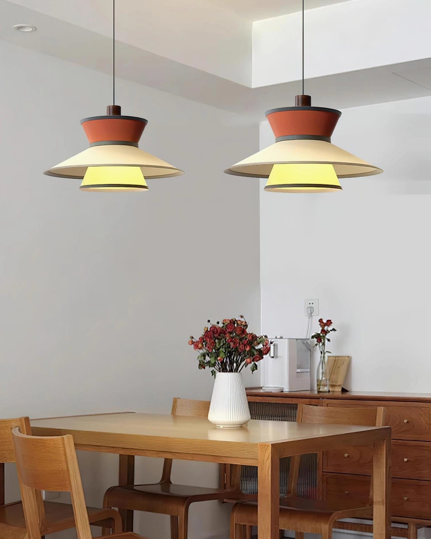 Modula pendant light in warm brown orange and yellow color variant, hanging in casual dining area