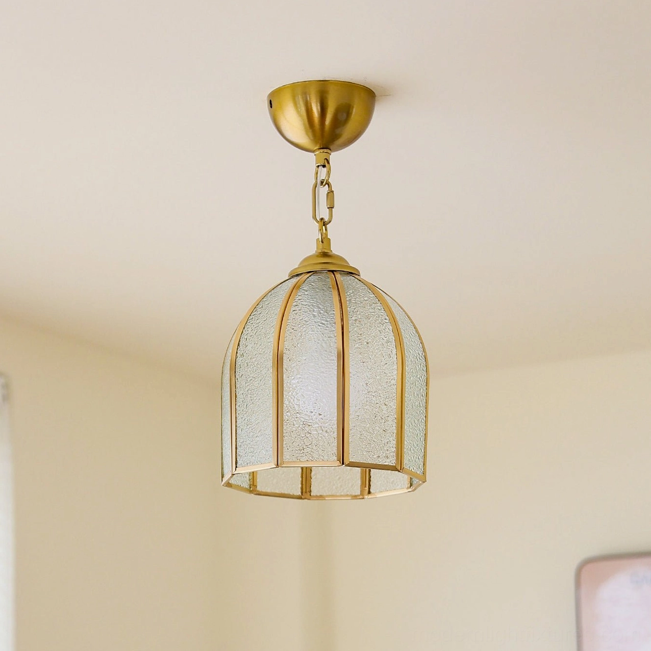 Moire frosted glass ceiling fixture in brass with overhead three-quarter angle view