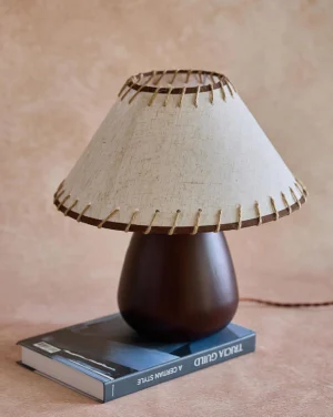 Molino modern table lamp three-quarter perspective on tabletop with hardcover book, showing brown twisted power cord