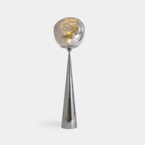 Molten glass cone floor lamp with silver metal pole and illuminated warm glass shade in modern studio setting