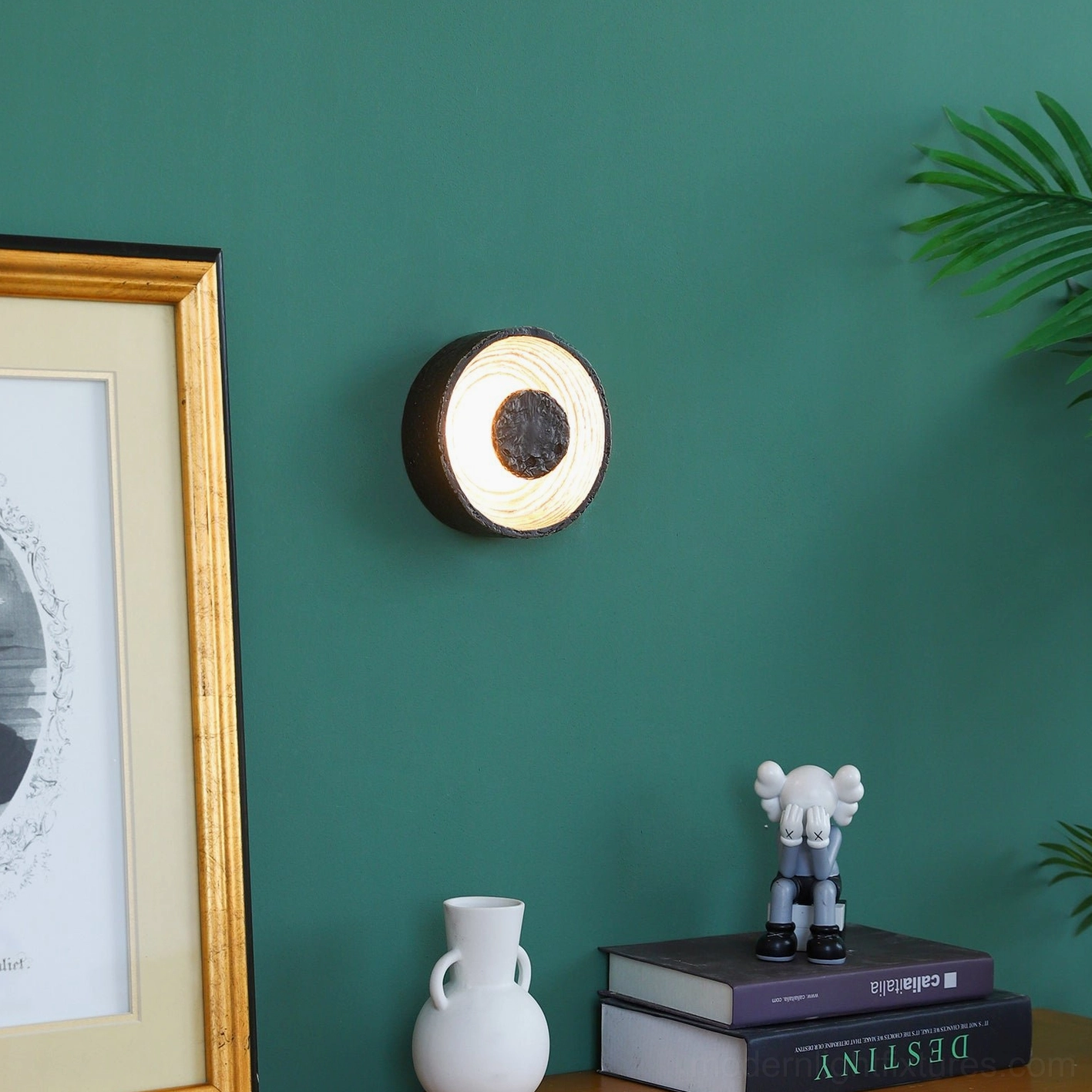 Contemporary black wall sconce with artistic molten texture mounted on green wall, eye-level shot with warm backlighting and minimalist styling