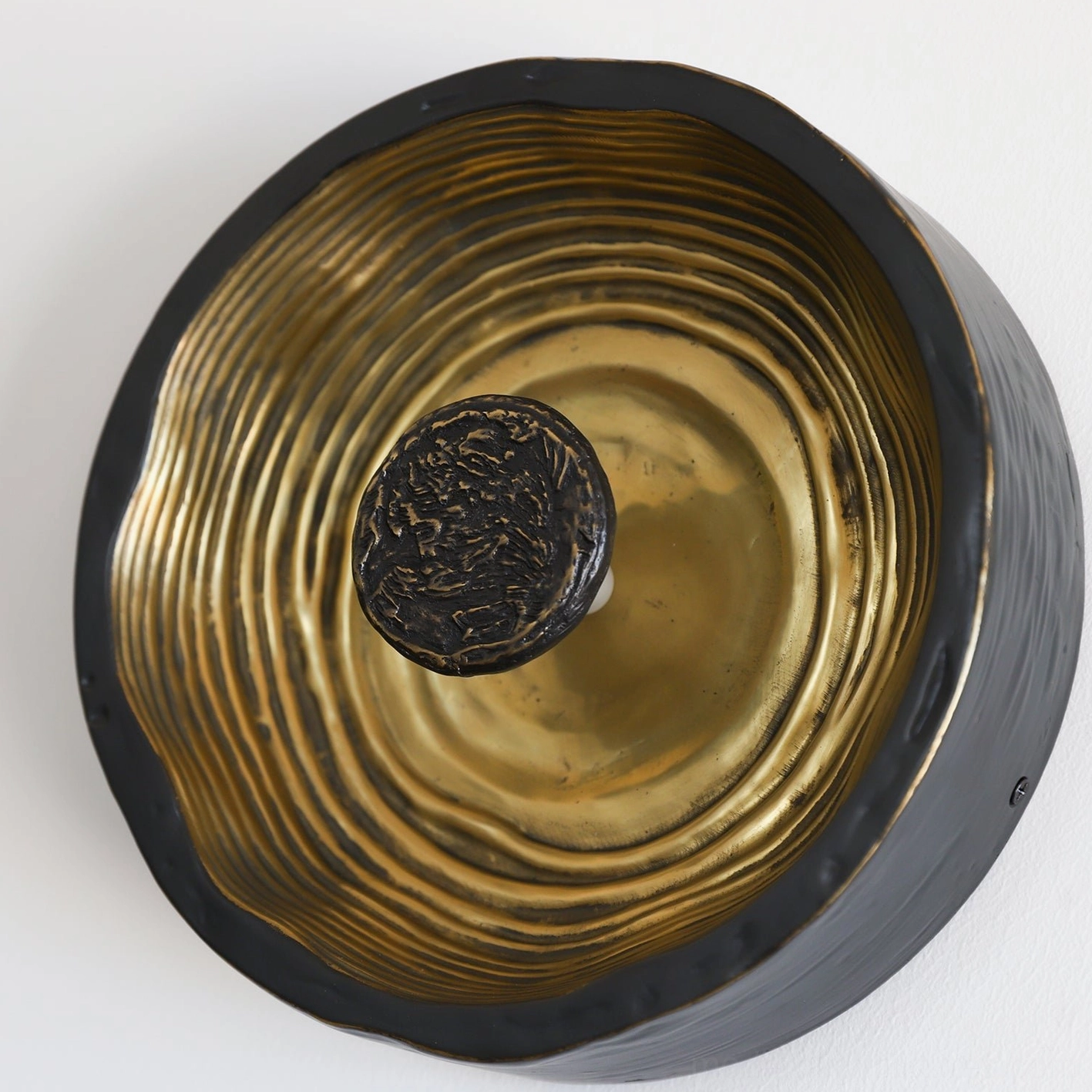 Moltena black wall sconce with warm 3000K LED lighting, creating intimate atmospheric illumination in modern bedroom