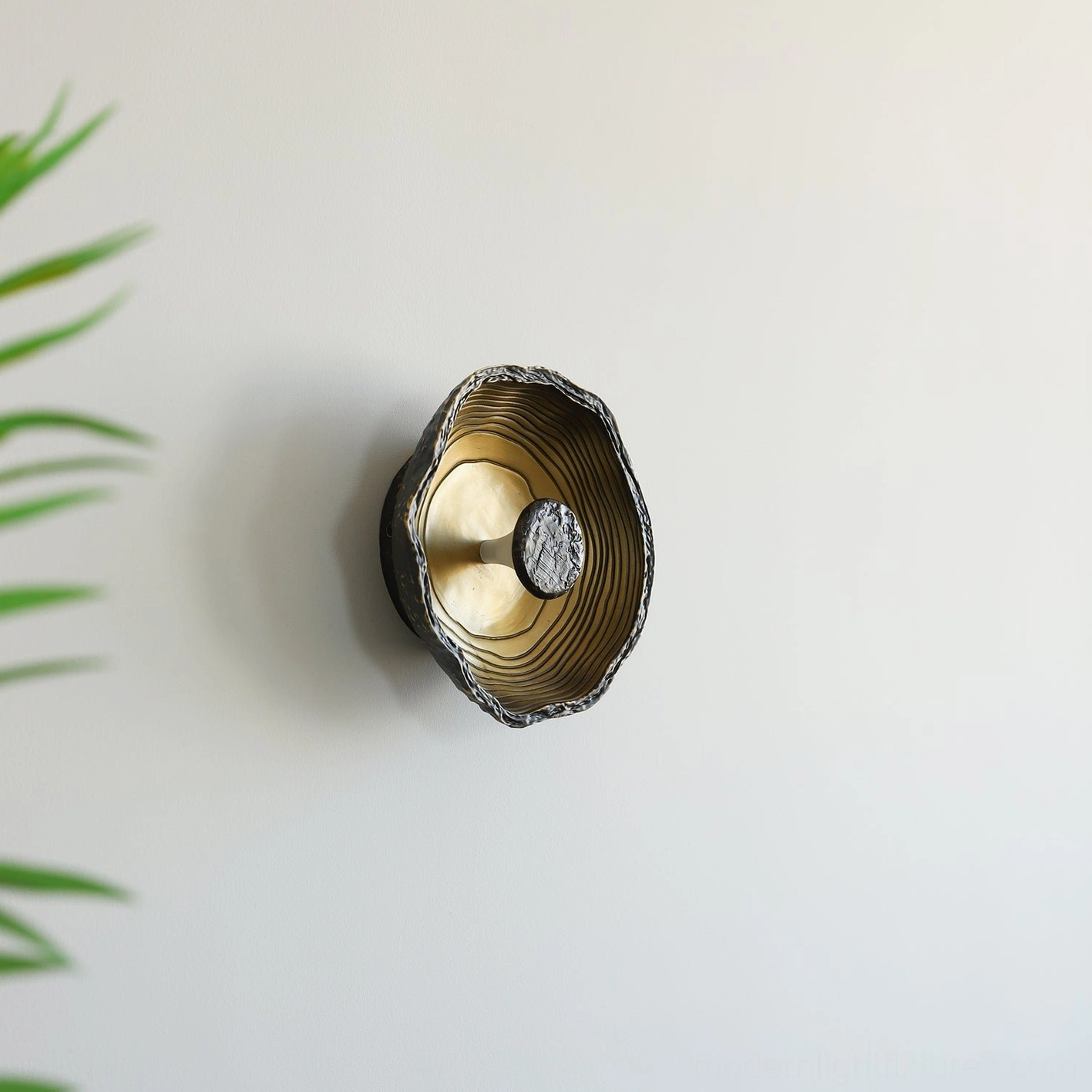 Pair of Moltena black wall sconces flanking bathroom vanity mirror, damp-rated fixtures with polished brass finish